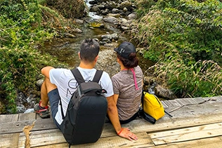 Momentos románticos: parejas disfrutan de nuestro pequeño puente colgante sobre un río. Naturaleza y amor en un solo lugar.
